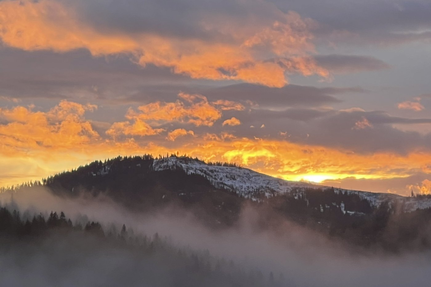 Front porch view west toward the meadow and ridgelines at winter sunset